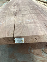 A walnut slab with visible wood grain and a visible QR label attached to the edge.